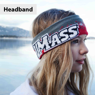 Person wearing a headband with 'UMass' text, standing by a body of water with mountains in the background.